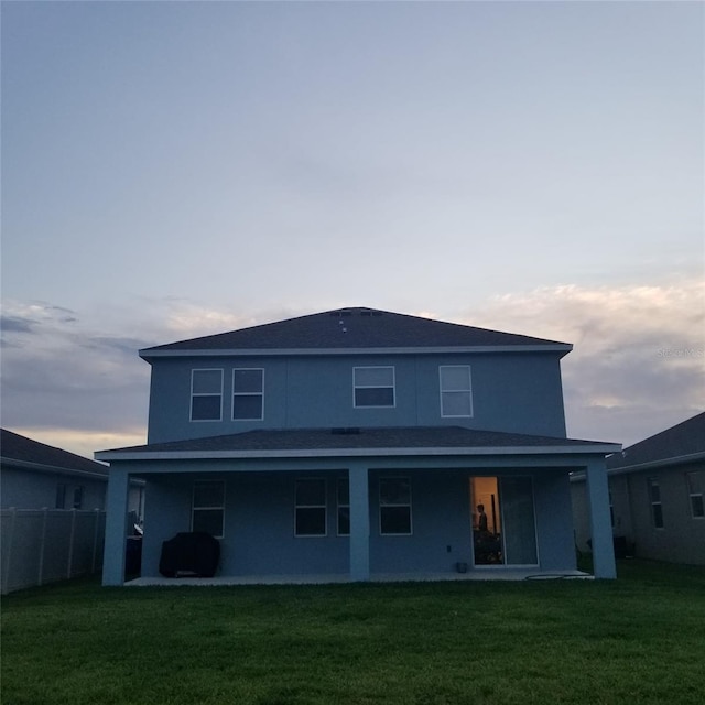 back house at dusk with a yard