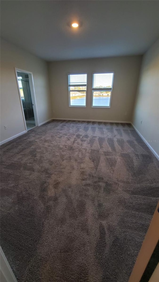 spare room with dark carpet