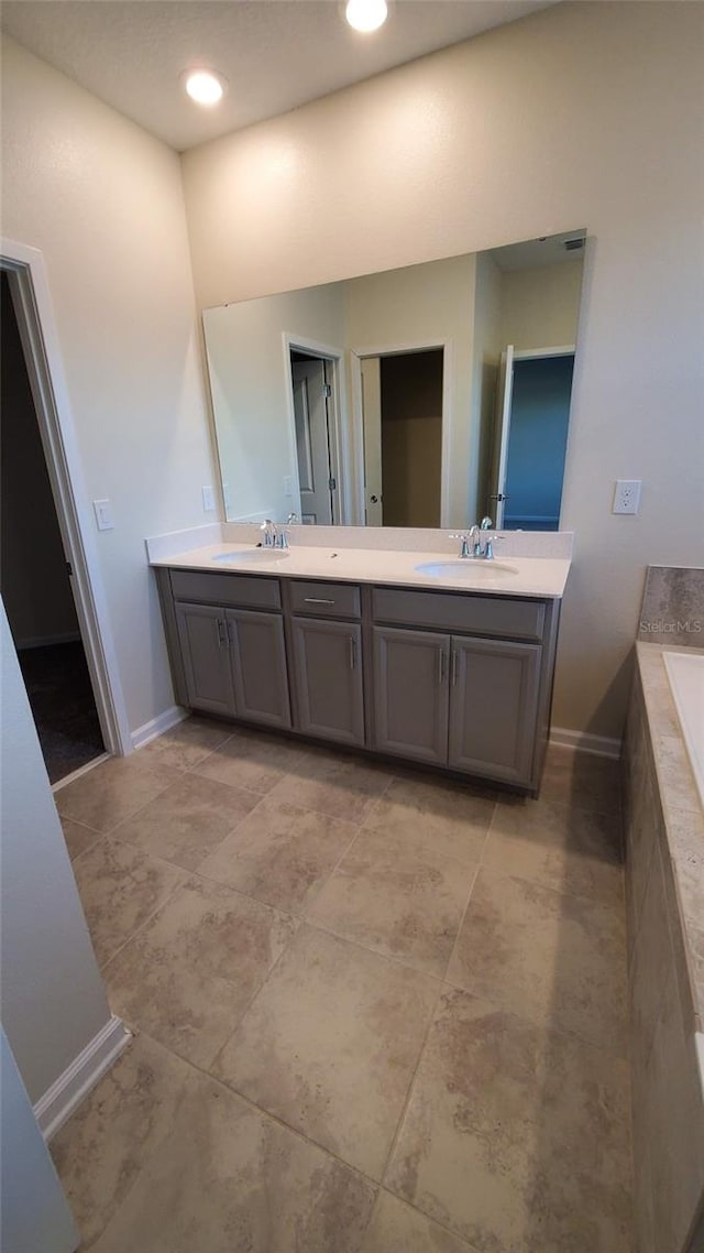 bathroom featuring vanity and tiled tub