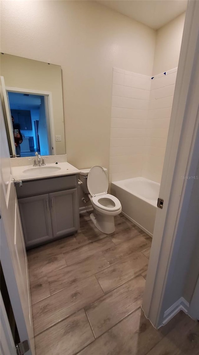 full bathroom with vanity, tub / shower combination, wood-type flooring, and toilet