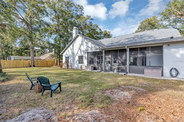 back of property with a yard and a sunroom