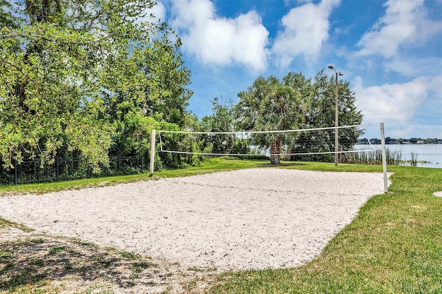 view of property's community featuring a lawn, a water view, and volleyball court