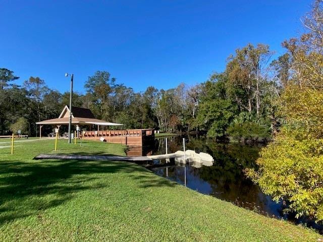 surrounding community with a yard and a water view