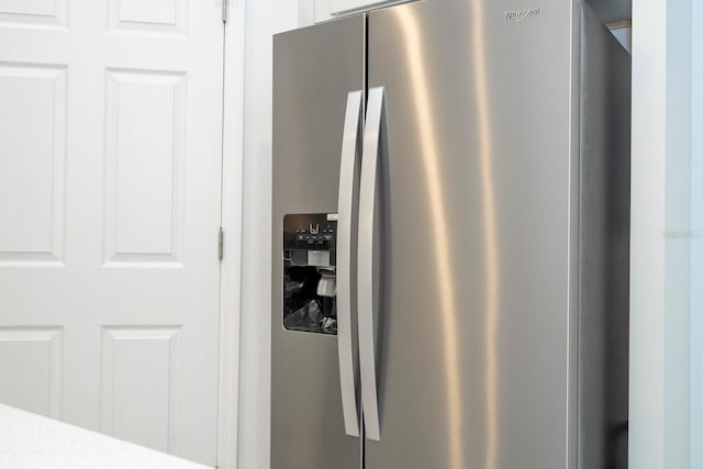 details with stainless steel fridge with ice dispenser and white cabinetry