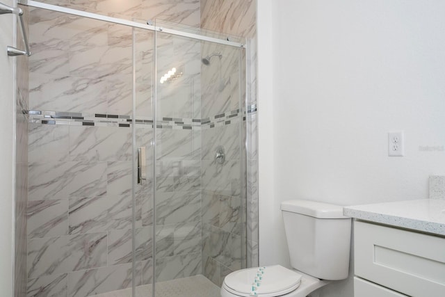 bathroom featuring toilet, an enclosed shower, and vanity