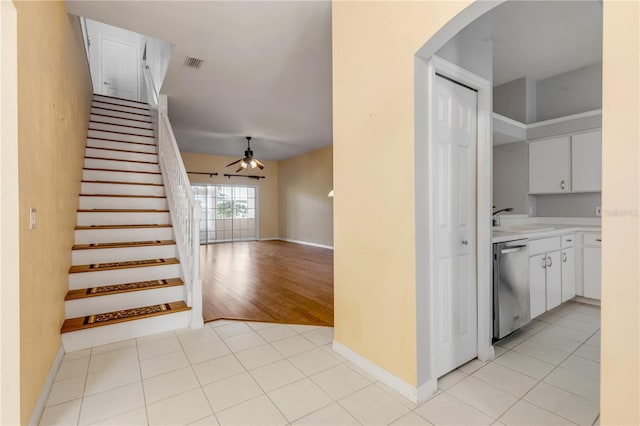 kitchen with white cabinetry, stainless steel dishwasher, ceiling fan, and light tile patterned flooring