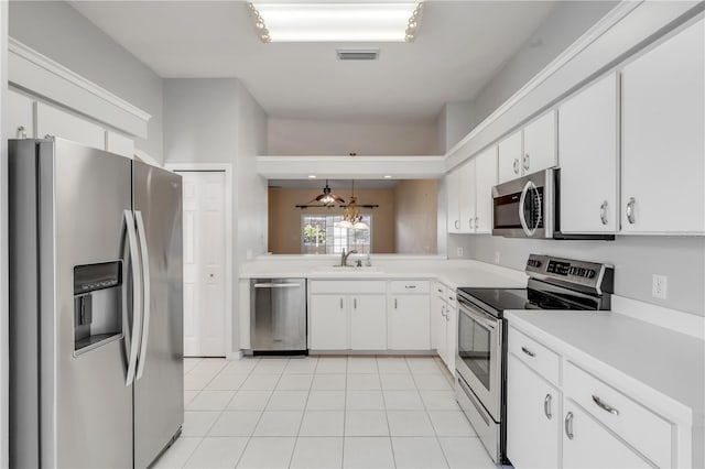 kitchen with stainless steel appliances, white cabinetry, hanging light fixtures, and sink