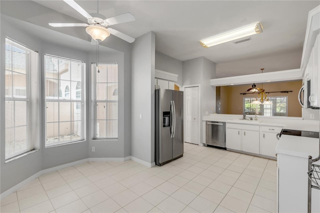 kitchen with appliances with stainless steel finishes, light tile patterned floors, and white cabinets