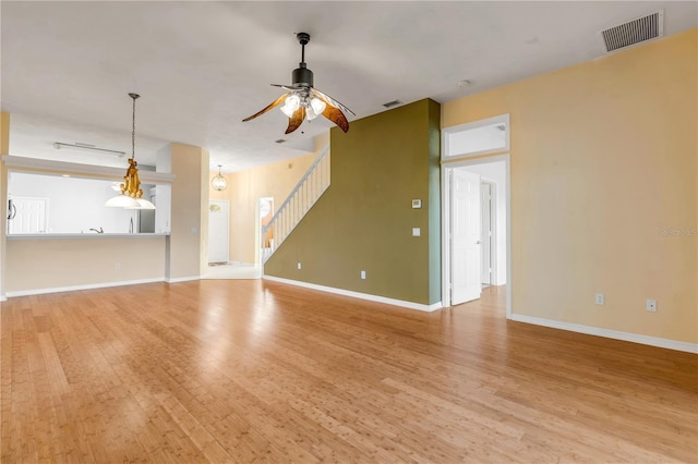 unfurnished living room featuring ceiling fan and light wood-type flooring