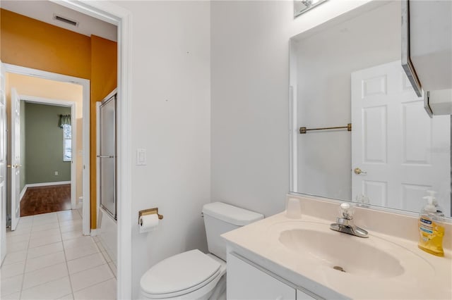 full bathroom with tile patterned flooring, vanity, enclosed tub / shower combo, and toilet