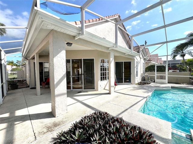 back of house with a lanai, a patio area, and a fenced in pool