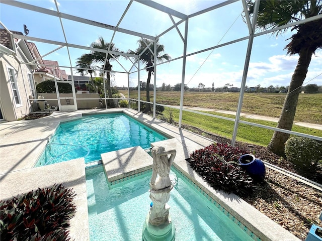 view of swimming pool with glass enclosure, a rural view, and a patio