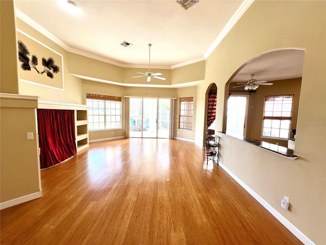 unfurnished living room featuring ceiling fan, crown molding, and light hardwood / wood-style floors