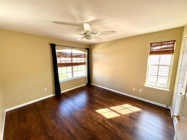 empty room with a textured ceiling, ceiling fan, and dark hardwood / wood-style floors