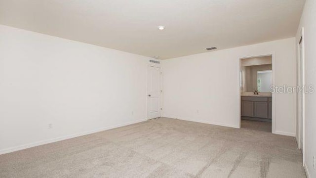 unfurnished room featuring light carpet