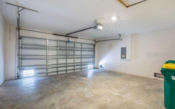 garage with a garage door opener and electric panel