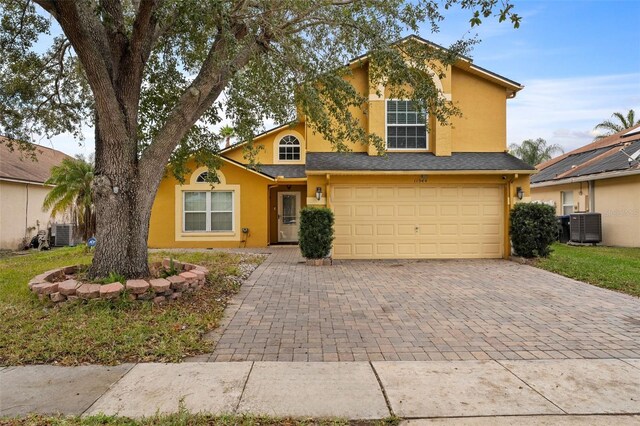 view of front of home featuring cooling unit and a garage