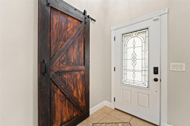 tiled foyer featuring a barn door