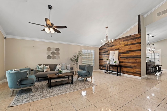 living room featuring a wealth of natural light, wood walls, ceiling fan with notable chandelier, and ornamental molding