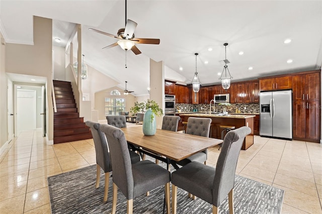 dining area featuring ceiling fan, light tile patterned floors, and vaulted ceiling