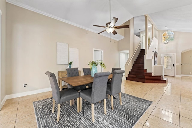 dining area with light tile patterned floors, high vaulted ceiling, ceiling fan with notable chandelier, and ornamental molding