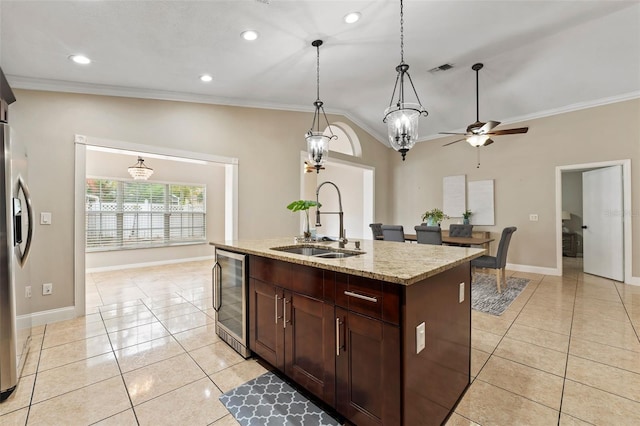 kitchen featuring wine cooler, a kitchen island with sink, sink, and ornamental molding