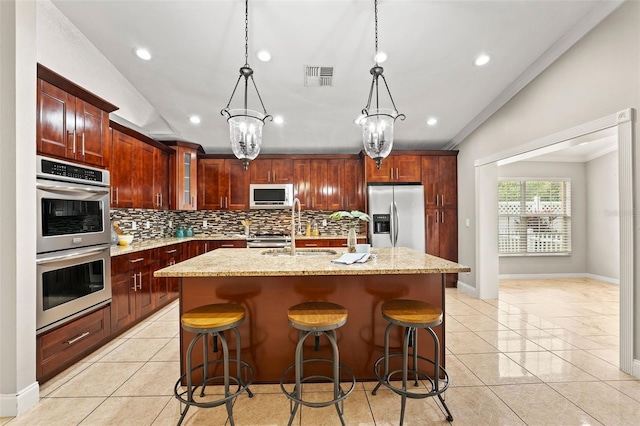 kitchen featuring ornamental molding, an island with sink, appliances with stainless steel finishes, and an inviting chandelier