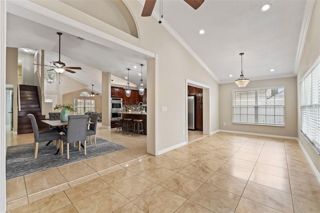 tiled dining space featuring crown molding, ceiling fan, and lofted ceiling