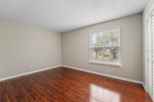 spare room with dark hardwood / wood-style floors