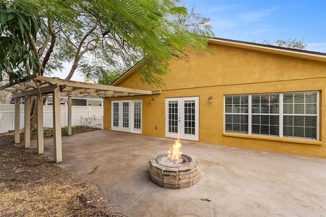 back of house with french doors, a pergola, an outdoor fire pit, and a patio area