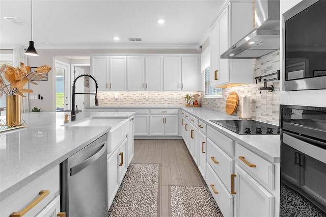 kitchen with black appliances, white cabinets, wall chimney exhaust hood, and light stone counters