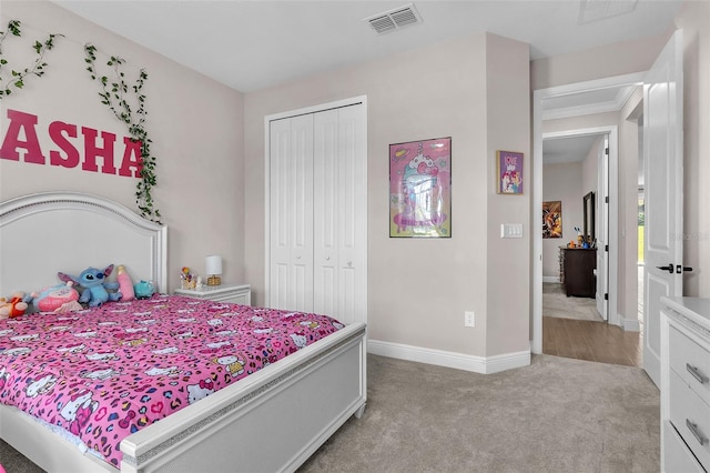 bedroom with a closet, ornamental molding, and light colored carpet