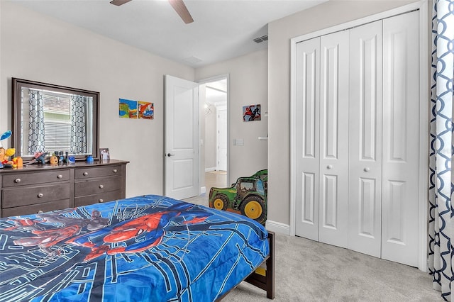 carpeted bedroom featuring ceiling fan and a closet