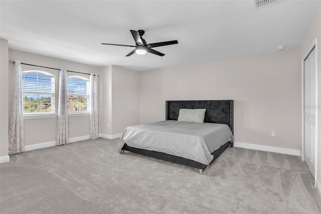 carpeted bedroom featuring ceiling fan and a closet