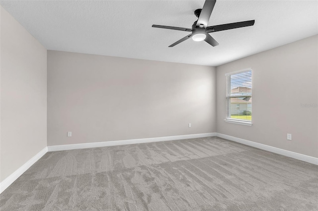 carpeted empty room featuring ceiling fan and a textured ceiling