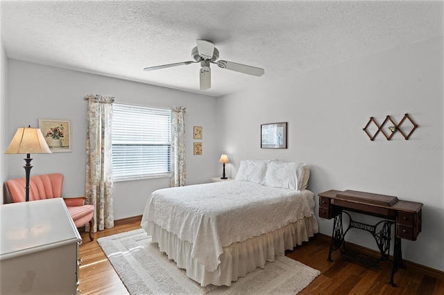 bedroom with ceiling fan, wood-type flooring, and a textured ceiling