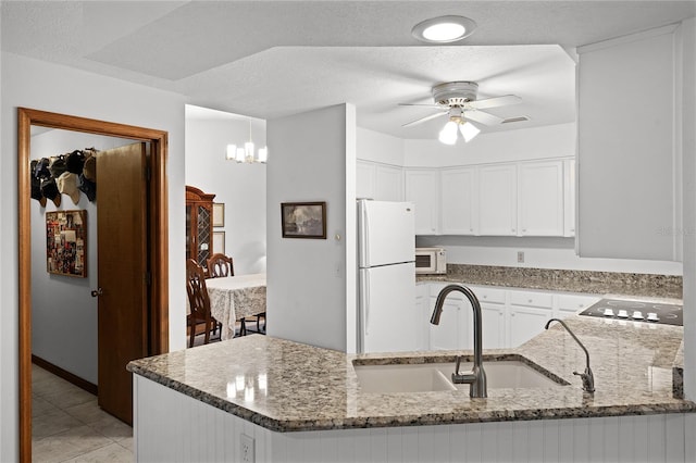 kitchen with ceiling fan with notable chandelier, white cabinetry, white appliances, and kitchen peninsula