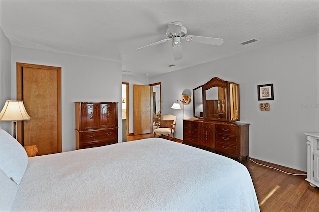 bedroom featuring a textured ceiling, dark hardwood / wood-style floors, and ceiling fan