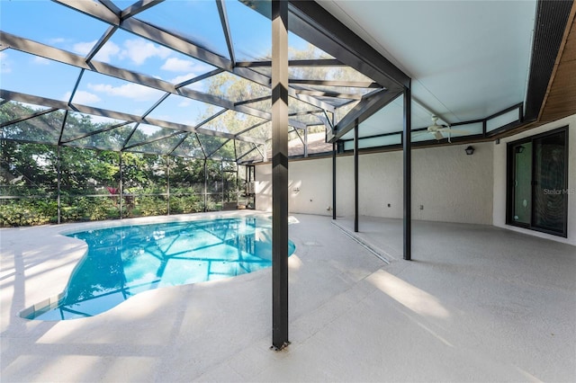 view of pool featuring glass enclosure, ceiling fan, and a patio