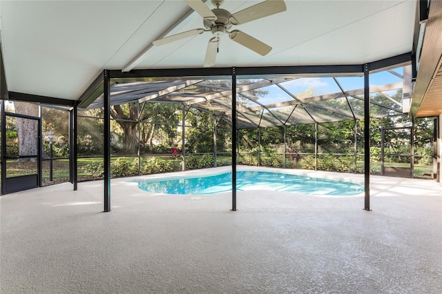 view of swimming pool with ceiling fan, a patio area, and glass enclosure