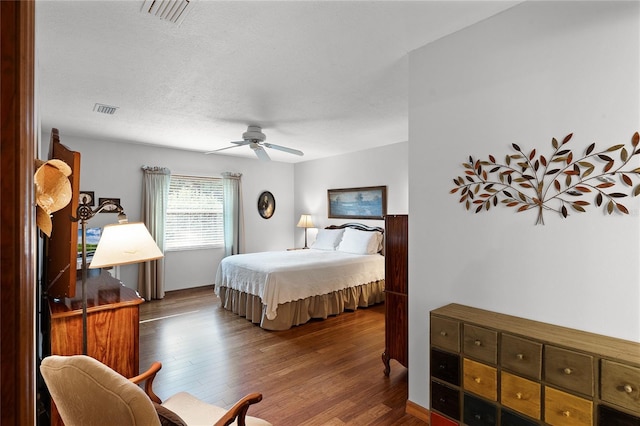 bedroom with hardwood / wood-style floors, a textured ceiling, and ceiling fan