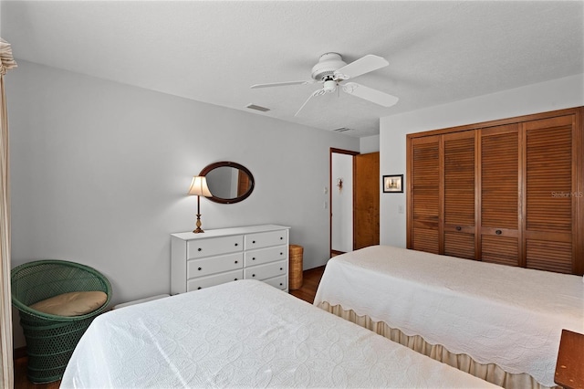 bedroom with ceiling fan, a closet, and a textured ceiling