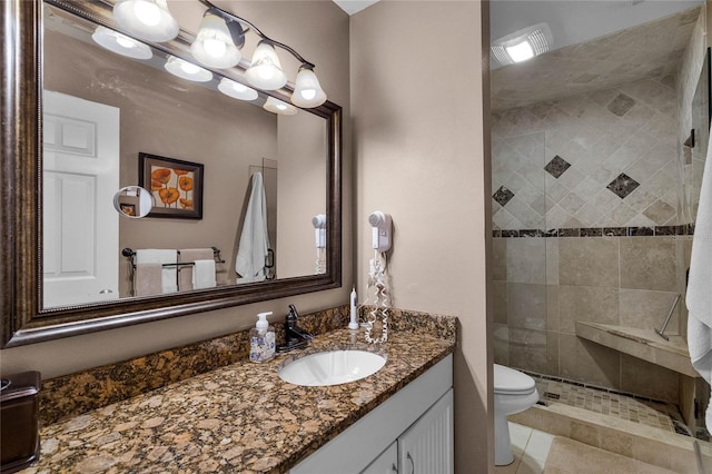 bathroom featuring tiled shower, vanity, and toilet