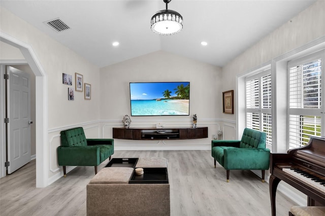 living room featuring light wood-type flooring and vaulted ceiling