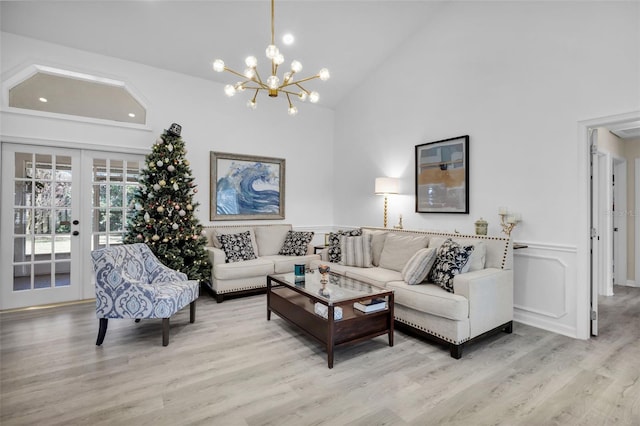 living room with french doors, high vaulted ceiling, light wood-type flooring, and an inviting chandelier