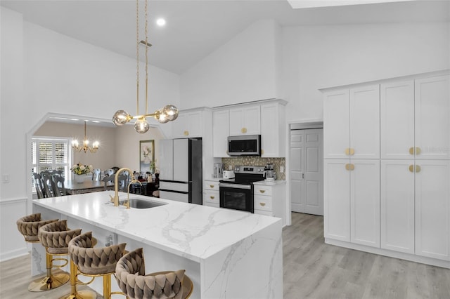 kitchen with appliances with stainless steel finishes, a kitchen island with sink, sink, high vaulted ceiling, and white cabinetry