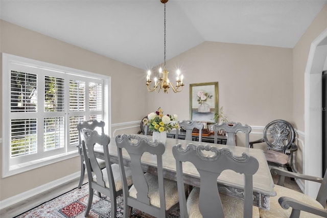 dining area featuring a wealth of natural light, lofted ceiling, and an inviting chandelier