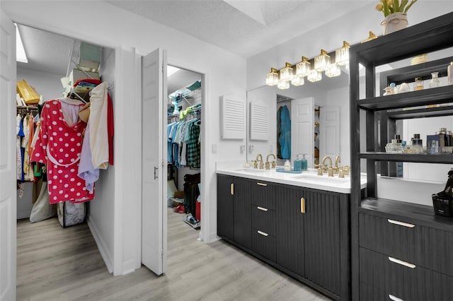 bathroom featuring vanity, wood-type flooring, and a textured ceiling