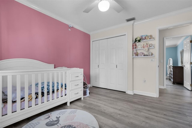 bedroom with hardwood / wood-style flooring, ceiling fan, crown molding, and a closet