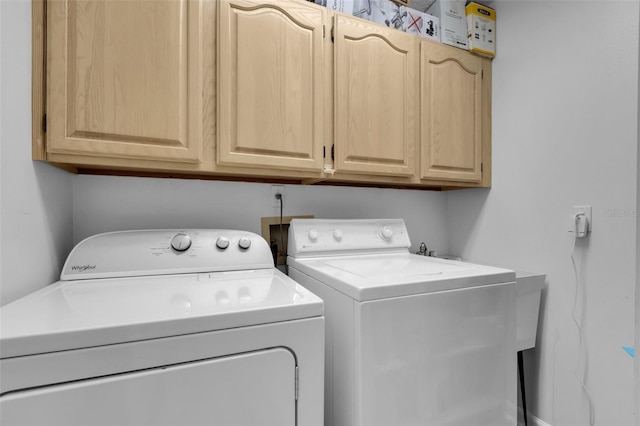 laundry area featuring washer and dryer and cabinets